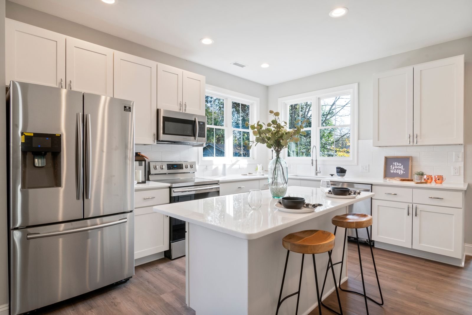 A bright, spotless kitchen with white cabinets and a tidy island after a routine clean