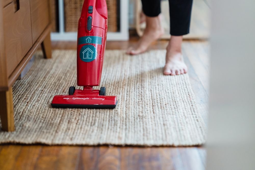 Vacuuming a rug in a warm, freshly tidied living room